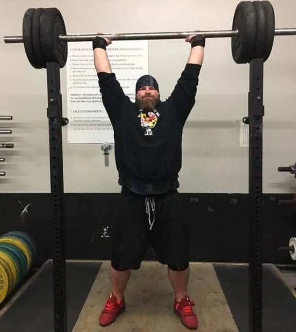 Jon Ward from Colosseum Strongman Performing A Front Barbell Press off the Rack