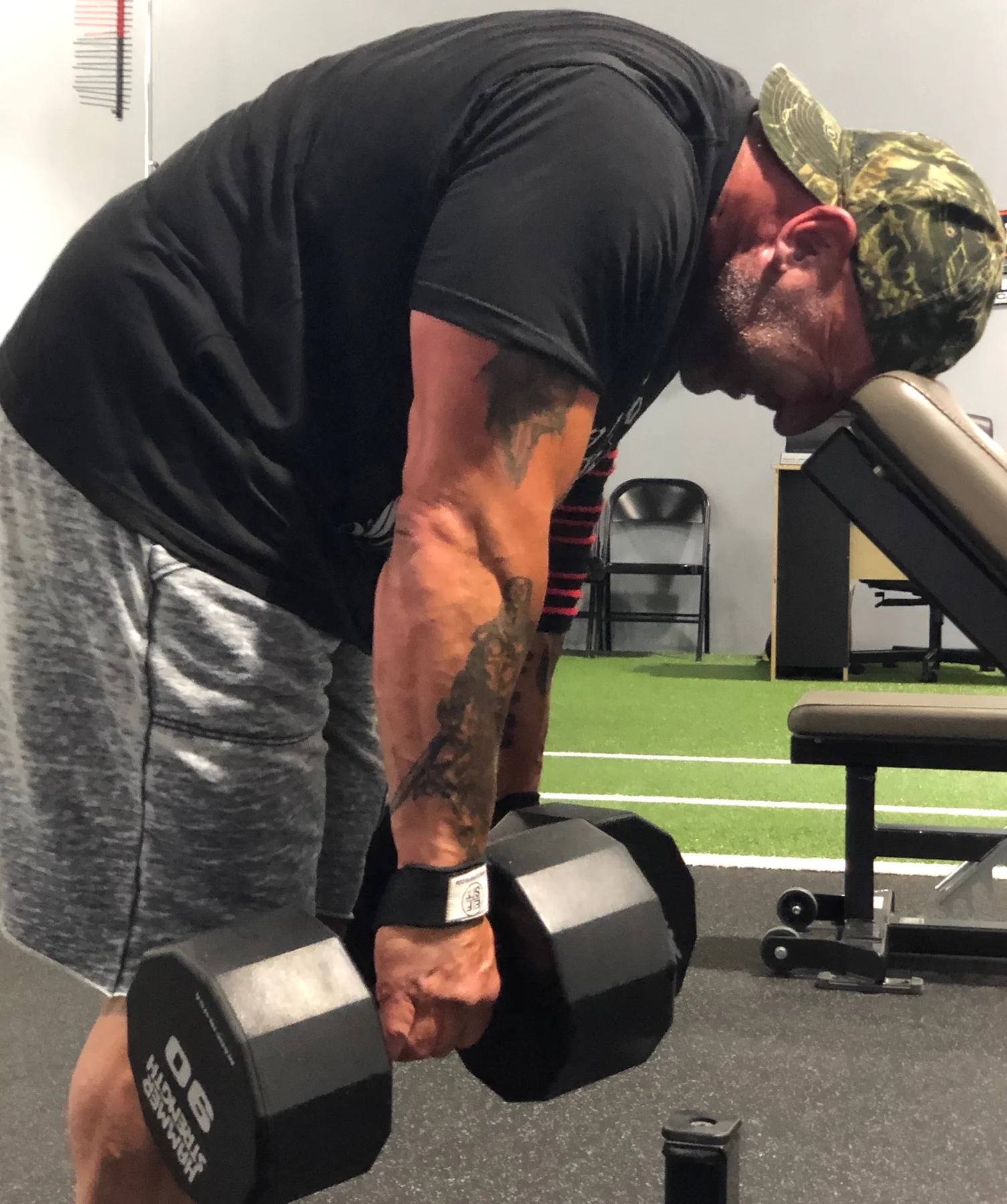 Athlete holding two 90 lb. dumbbells