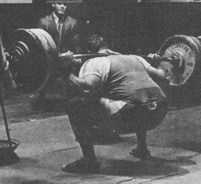 Hugh Cassidy performing a heavy barbell squat in his basement gym. Article by Marty Gallagher.