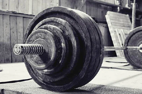 oaded Olympic barbell and weight plates on a gym floor