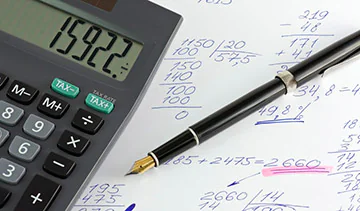 Calculator shown with pen and paper crunching numbers for a fitness equipment budget.