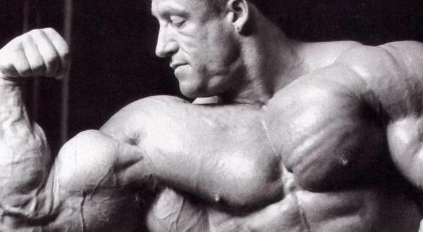 Bodybuilder flexing one arm to display upper-body muscle