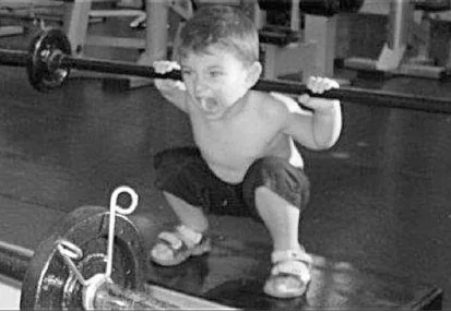 Young child performing a deep barbell back squat