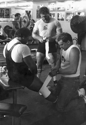 Powerlifter getting knee wraps before competition