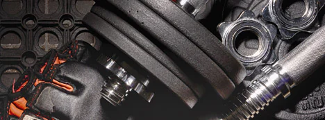 Garage gym equipment with dumbbells, barbells and rubber flooring