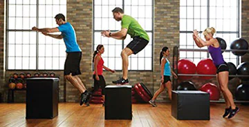 Gym members shown performing plyometrics workouts on plyo boxes.