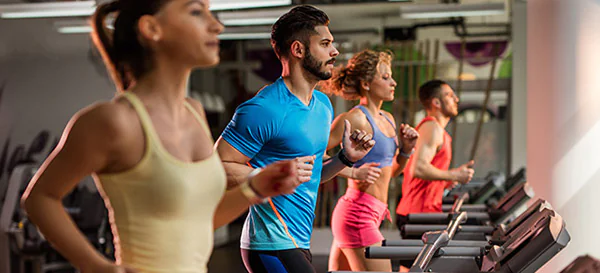 Athletes running on treadmills in a gym