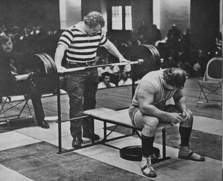 Athlete setting up for a barbell bench press at a competition