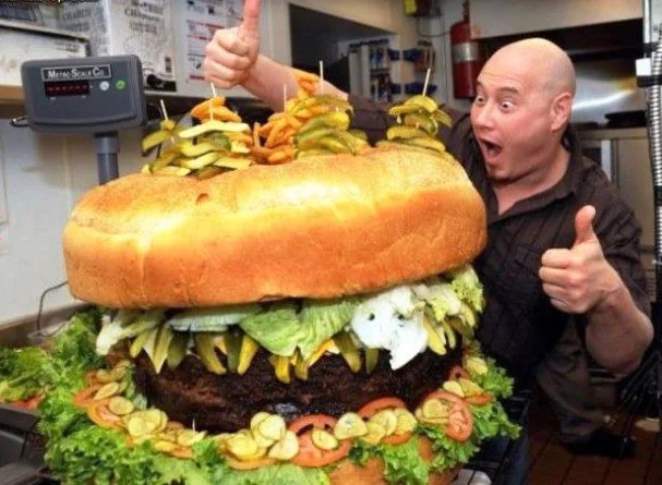 Chef posing with oversized hamburger for nutrition article