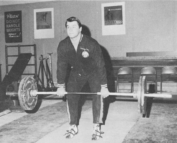 Tommy Suggs performing a deadlift with a loaded barbell