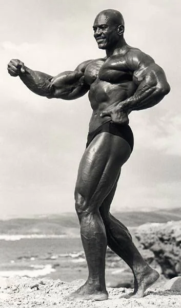 Sergio Oliva flexes his massively muscular arms.