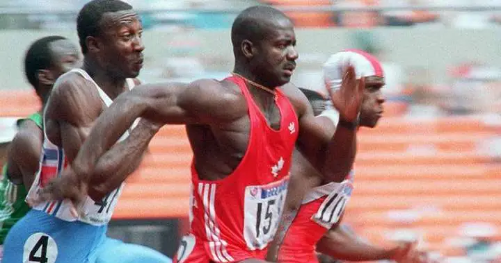 Ben Johnson running on a track in red uniform