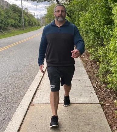 Big man powerwalking on sidewalk for cardio training