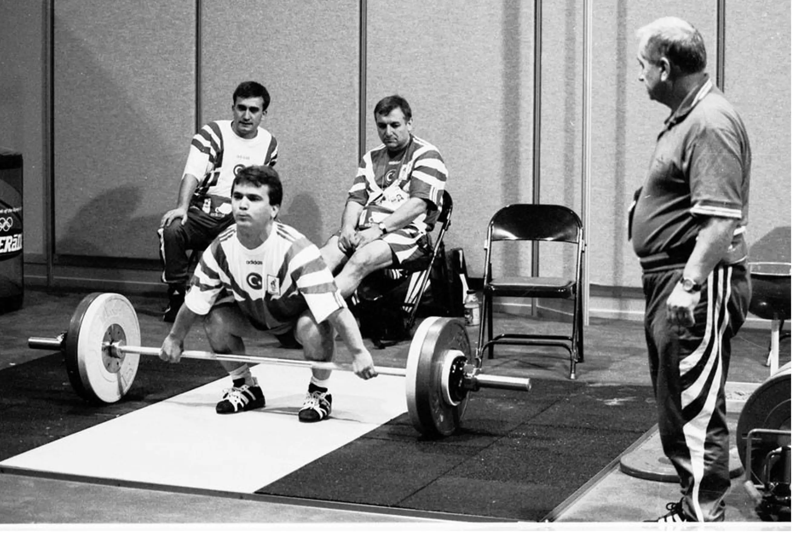 Athlete receiving coaching backstage before a weightlifting attempt