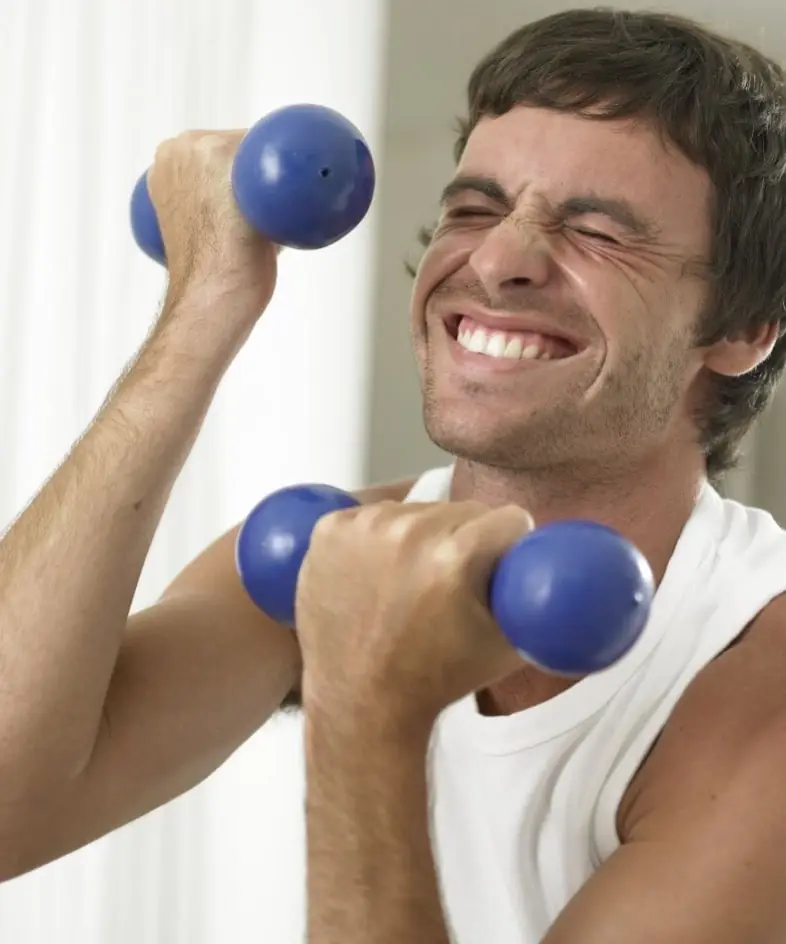 Man performing a bicep curl in a gym