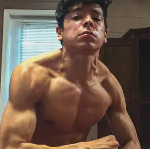 Teen flexing arm and chest muscles after weight training