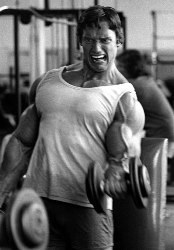Bodybuilder performing a dumbbell curl to create a muscle pump