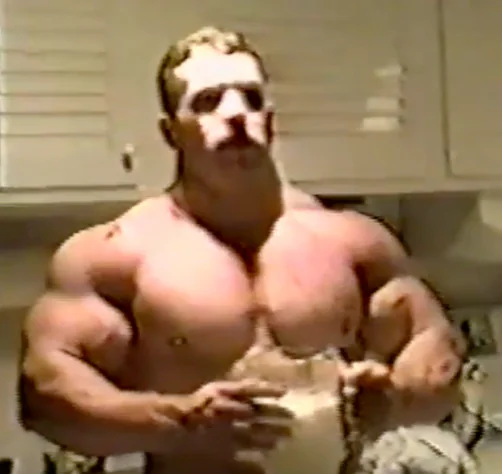 Muscular powerlifter posing indoors during an upper-body specialization phase