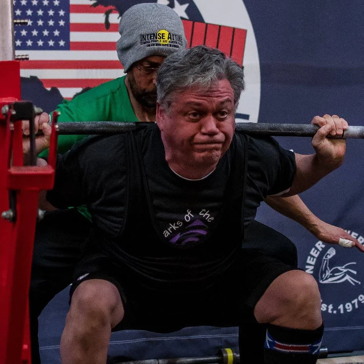 Powerlifter at the bottom of a 390-pound barbell squat