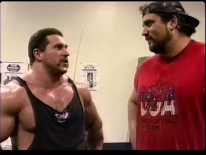Two strength athletes standing together in a gym